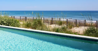 Dunes and the ocean just beyond a pool ledge